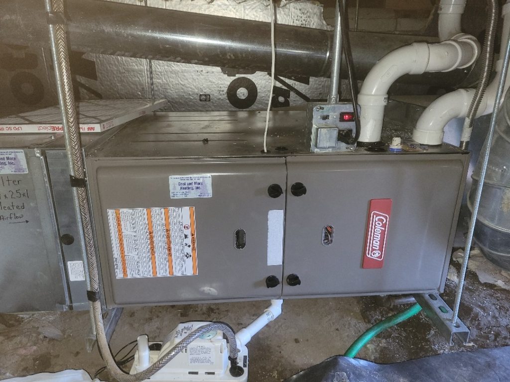 Technician repairing gas furnace in Powell WY crawl space